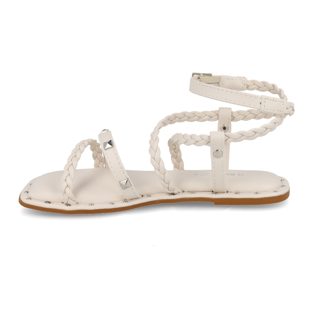 Vista lateral da sandália M Shuz Kids off white mostrando tiras trançadas e detalhes em tachas prateadas